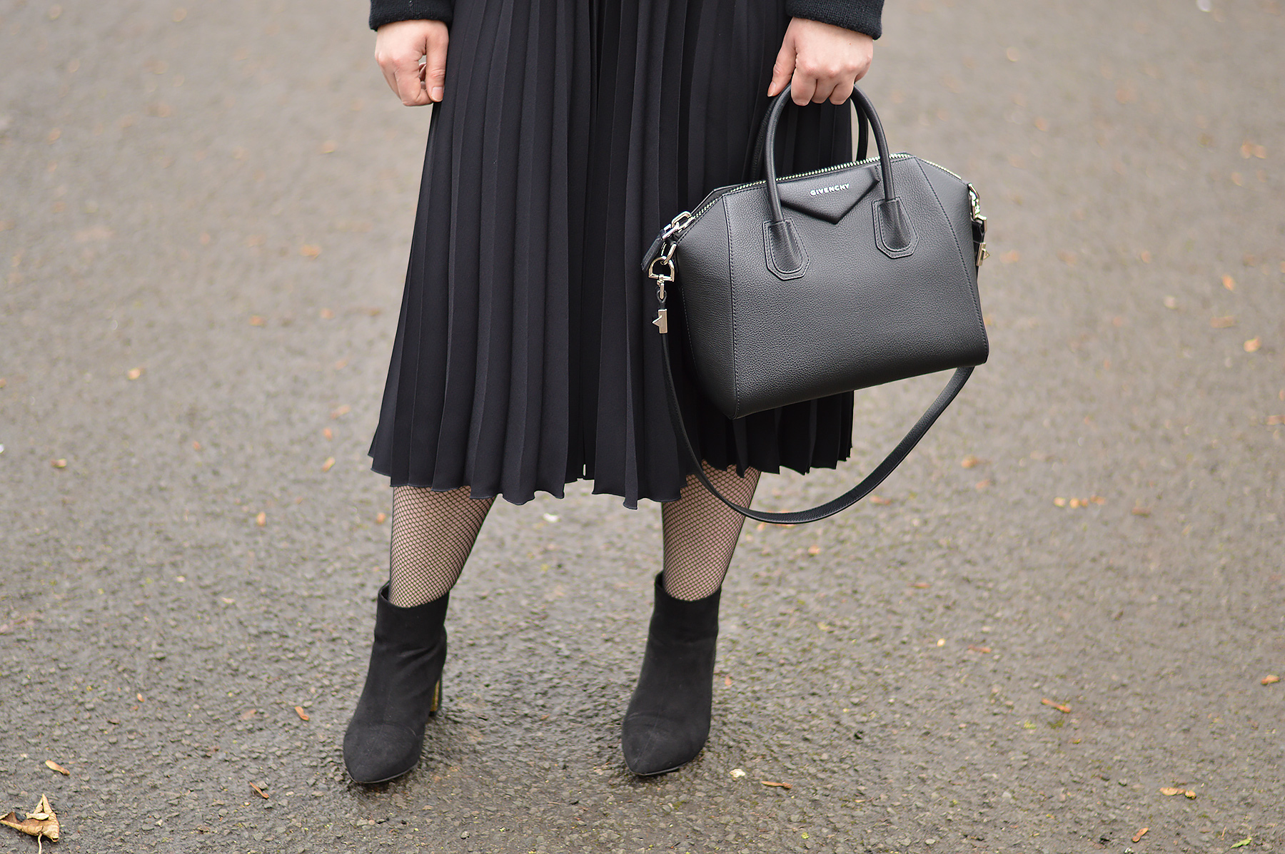 Black pleated skirt and fishnet tights