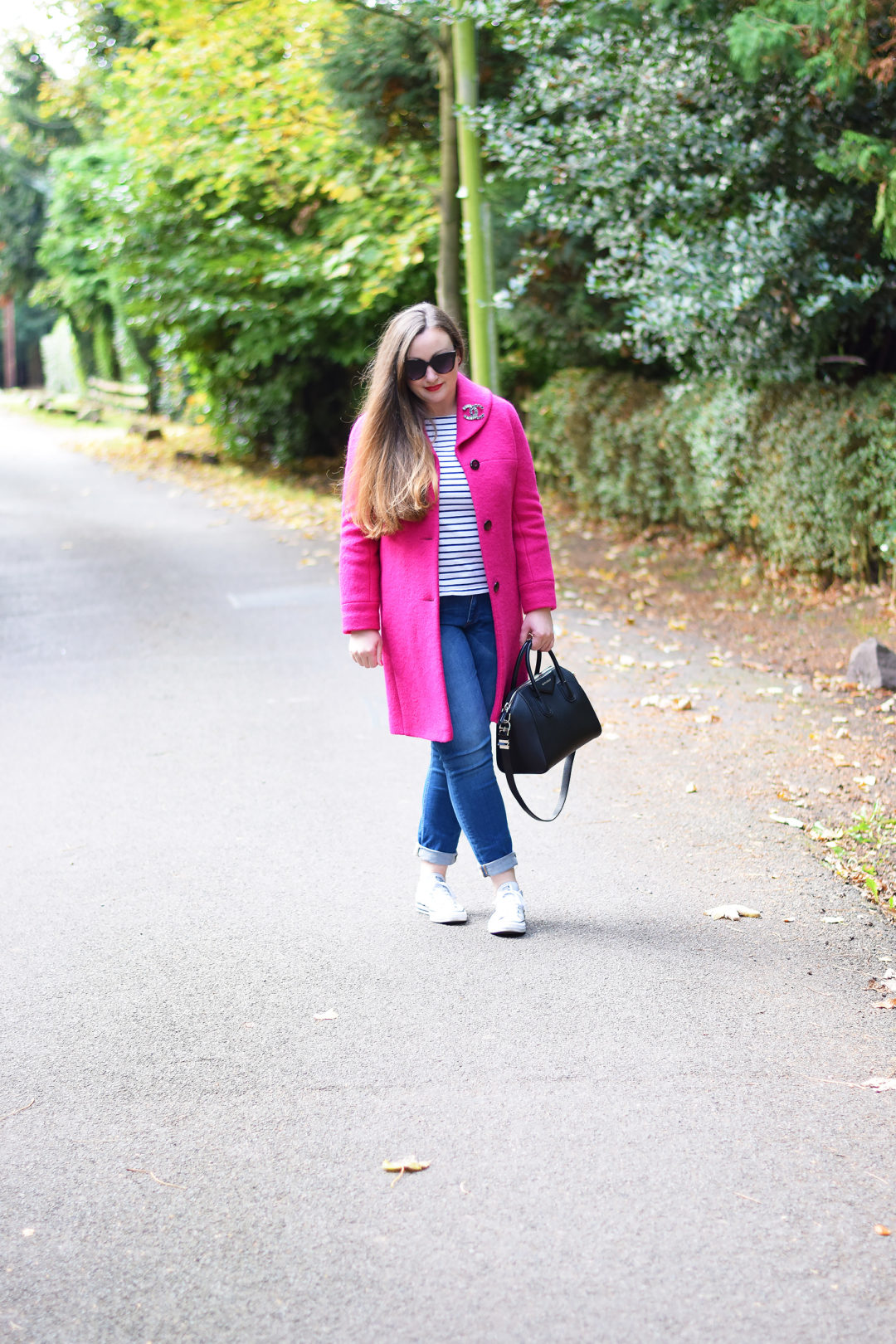 Bright pink coat and a chanel brooch