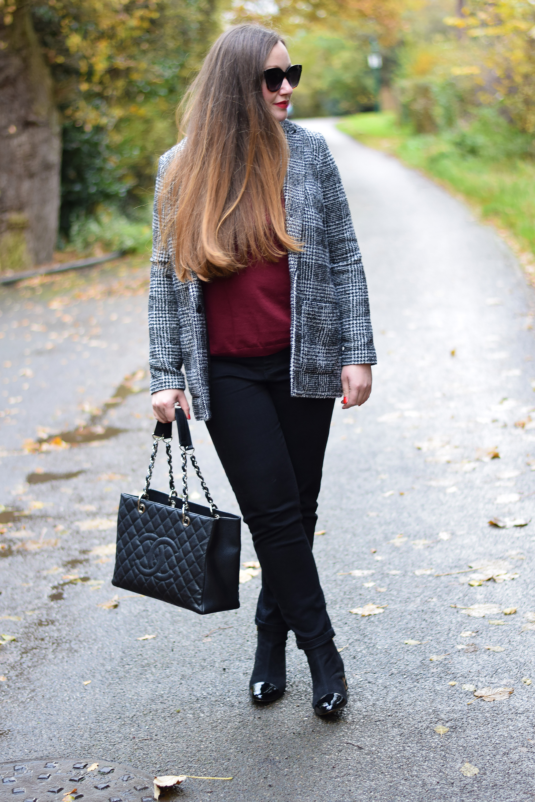 Burgundy sweater with black jeans and checked jacket
