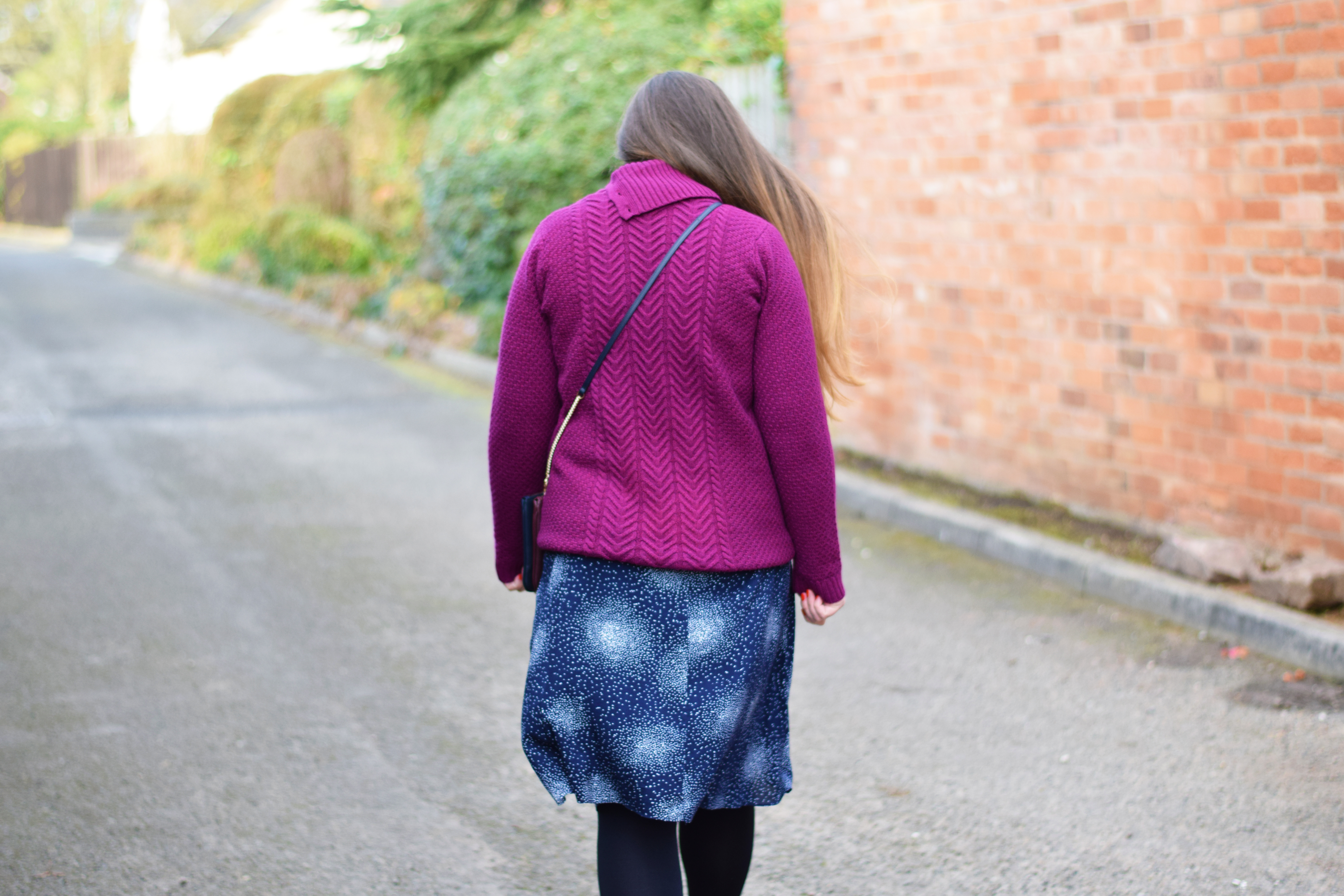 Purple chunky knit jumper with a navy and white skirt