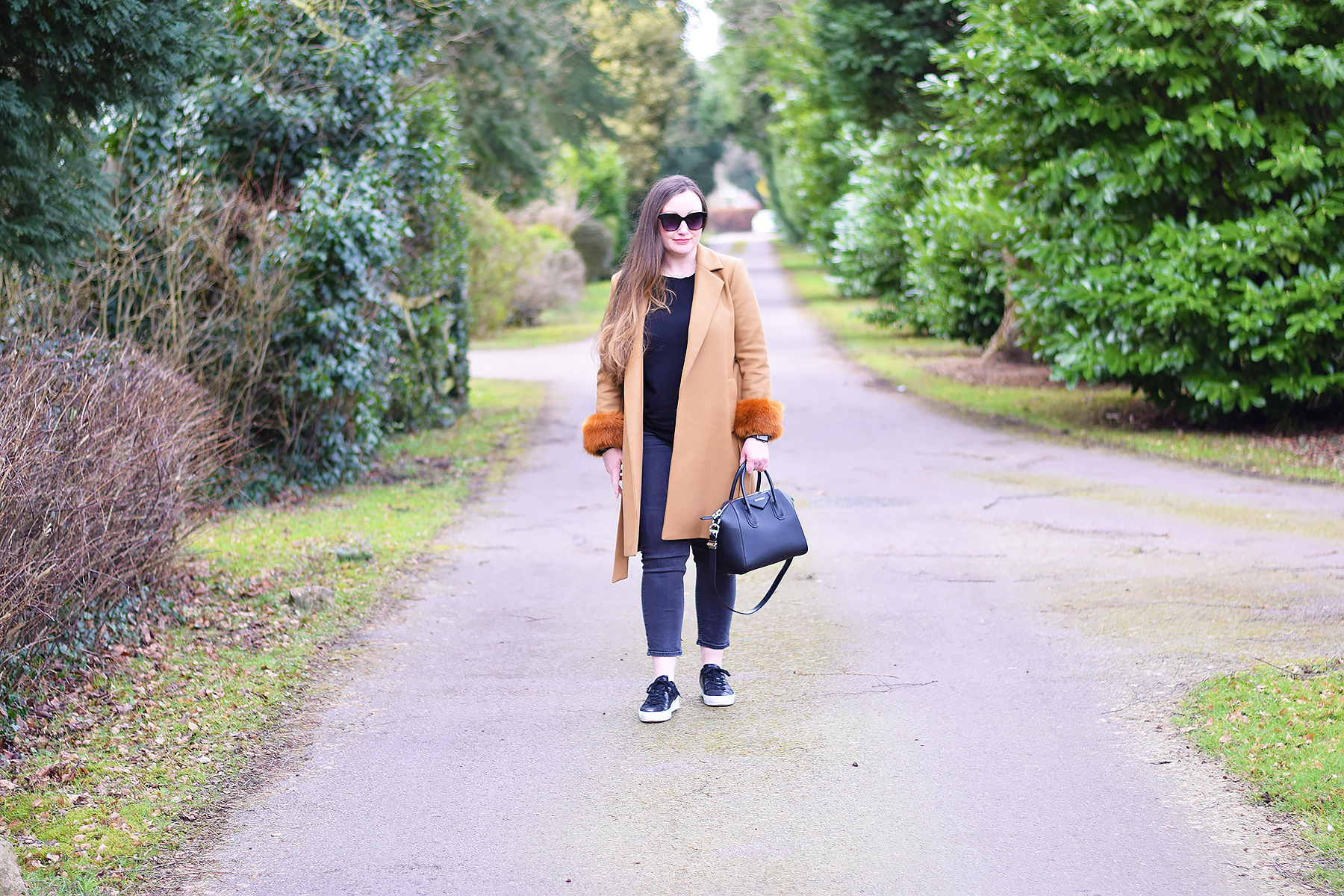 camel coat and black trainers outfit